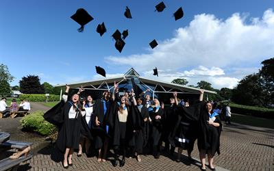 Graduates throwing mortarboards in the air
