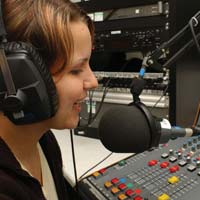 female radio presenter talking into microphone on air