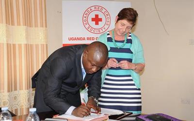 Sue Allen signing MoU in Uganda
