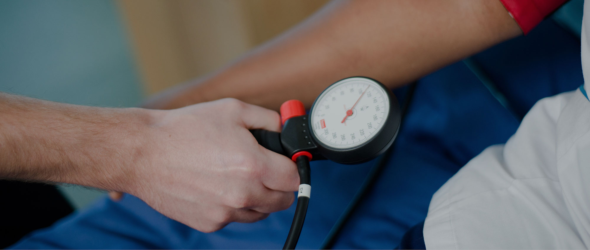 A healthcare professional measures a patient's blood pressure using a sphygmomanometer.