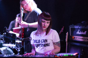 A girl playing piano and a male behind her on bass