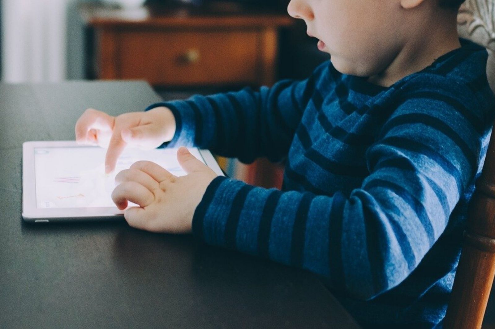 Photo of a young child looking at an ipad