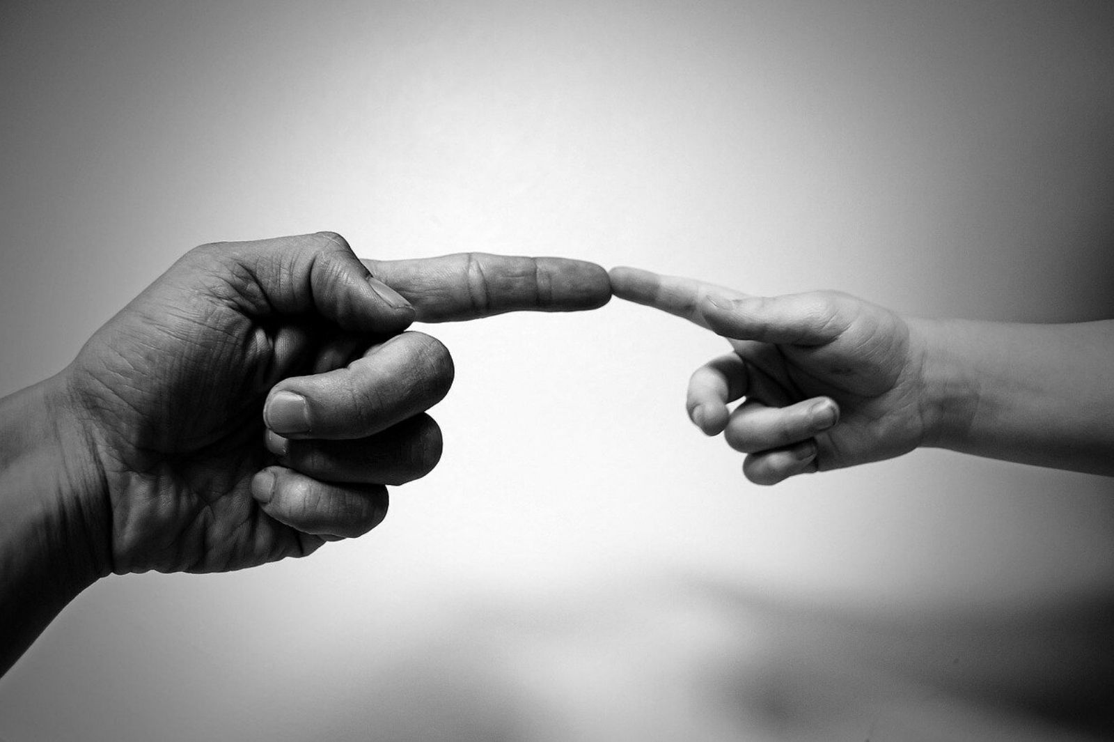 Adult's and child's hands with fingers touching