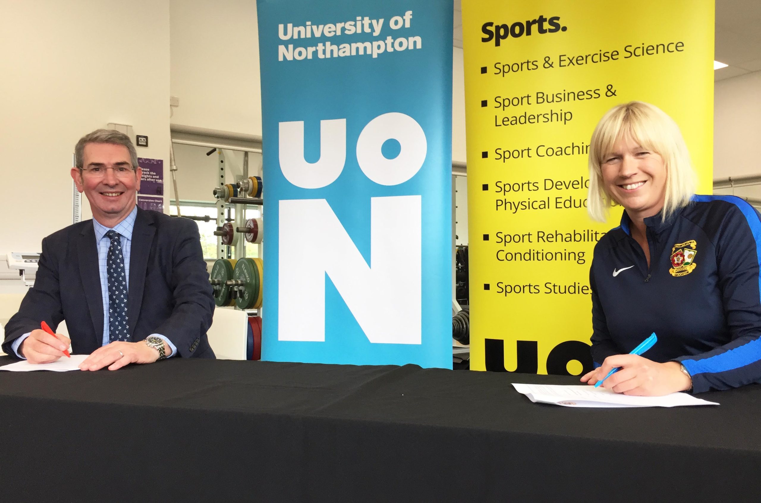 John Sinclair, Dean of the Faculty of Arts, Science and Technology at the University of Northampton, left, signs the MOU with Sarah Bentley, CEO of Northamptonshire Football Association.