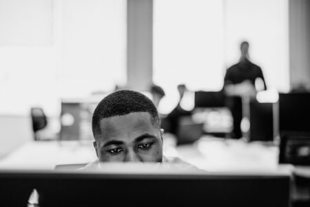 A student working at a laptop in a socially distanced class room