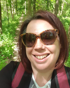 Victoria Blake, Environment and Sustainability Manager, standing in green forest