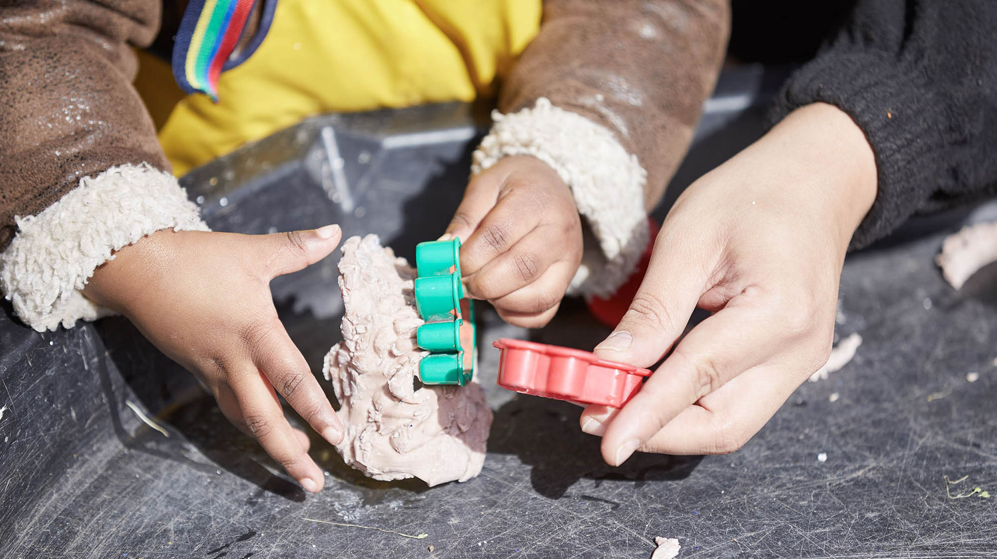 Child and adult playing with cookie cutters