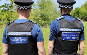 Police officers facing away from the camera, to show their 'Police Officer Support Officer' badge