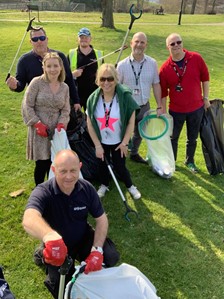 Staff and Students smiling at the camera, holding trash bags and pick-up sticks for litter picking at the University of Northampton's Go Green Week in 2022.