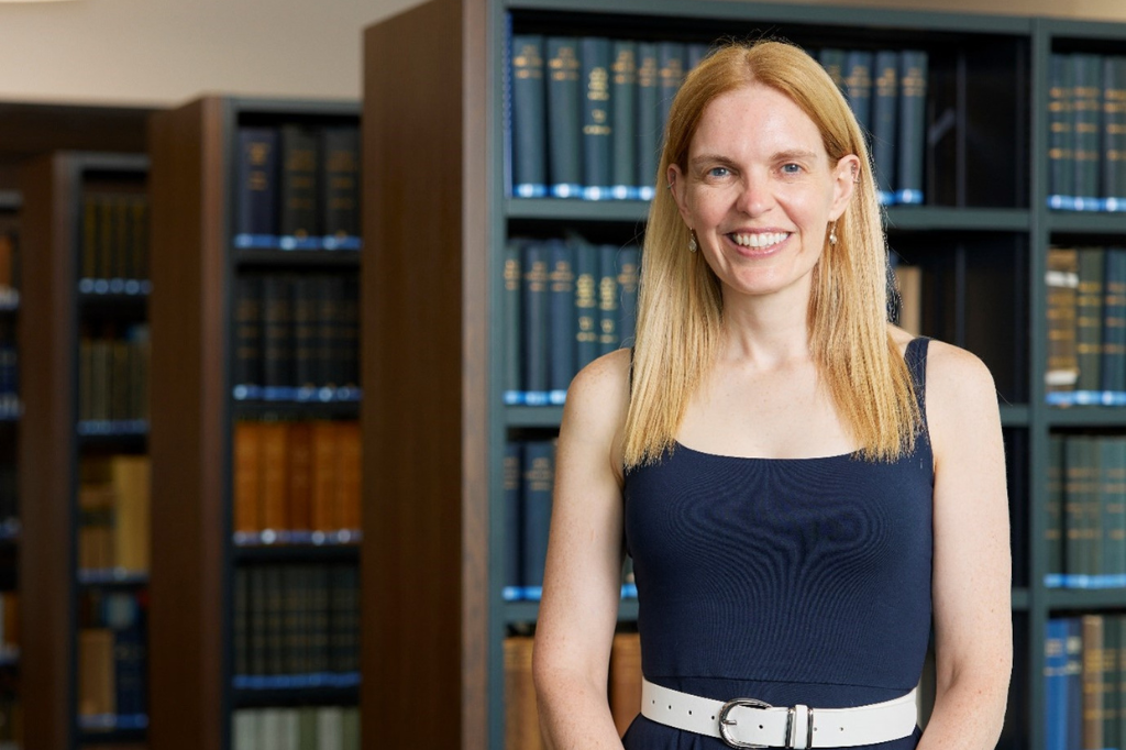 Anne-Marie Kilday stands in front of library books