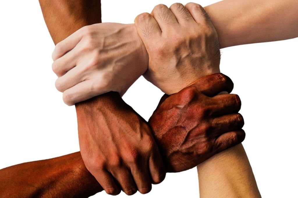 People of different ethnicities hold wrists