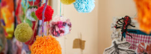 Colourful pom poms hanging from the ceiling