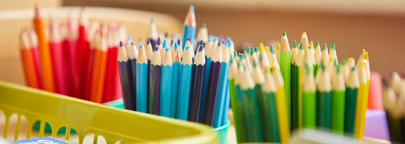 Side view of colourful pencils in pots. Divided into: reds and oranges, blues, and green and yellow.