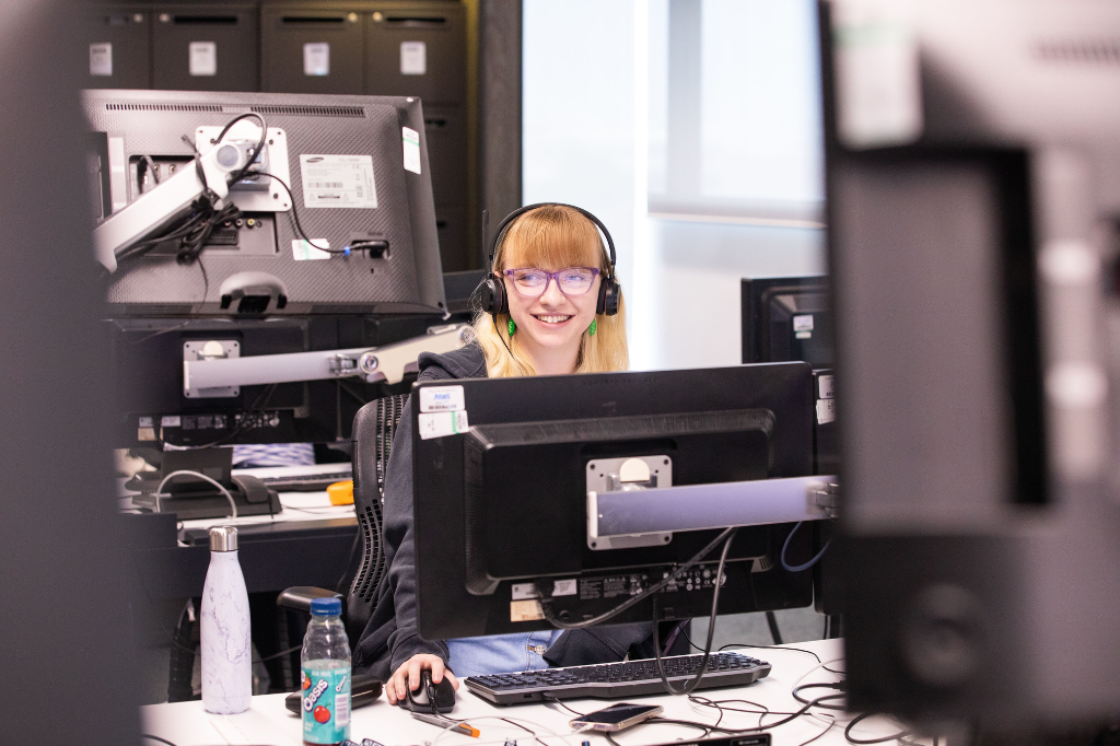 Graduate surrounded by computers at the BBC