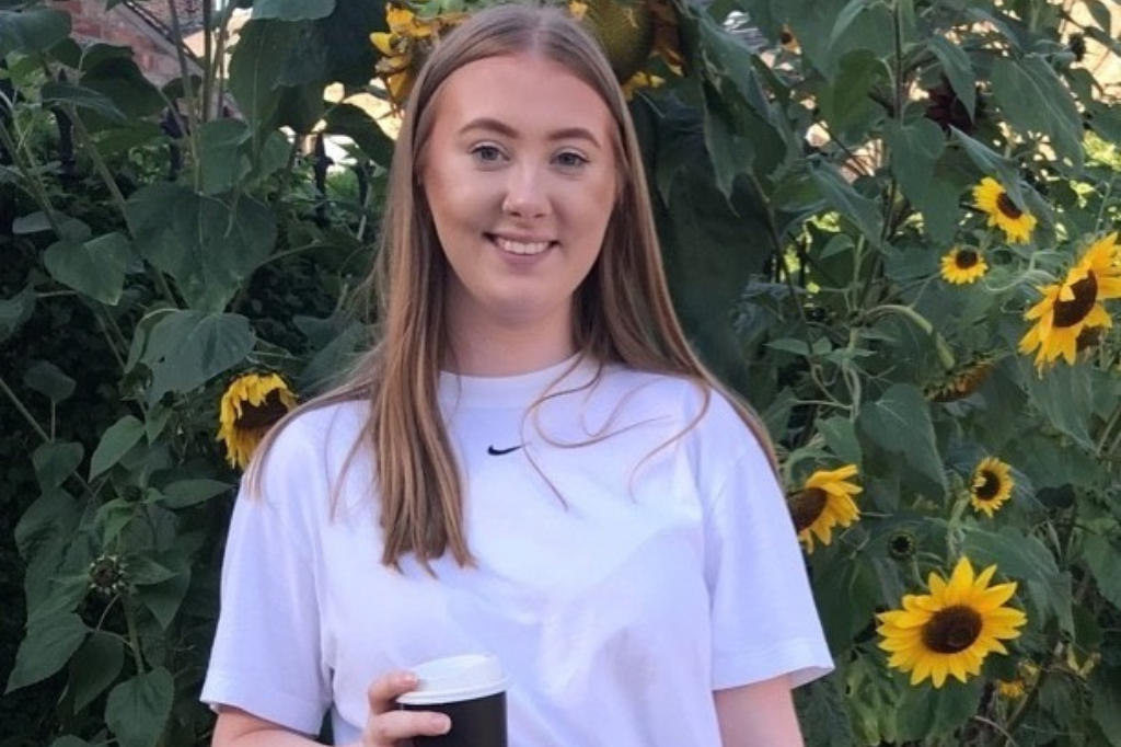 Student stood in front of sunflowers