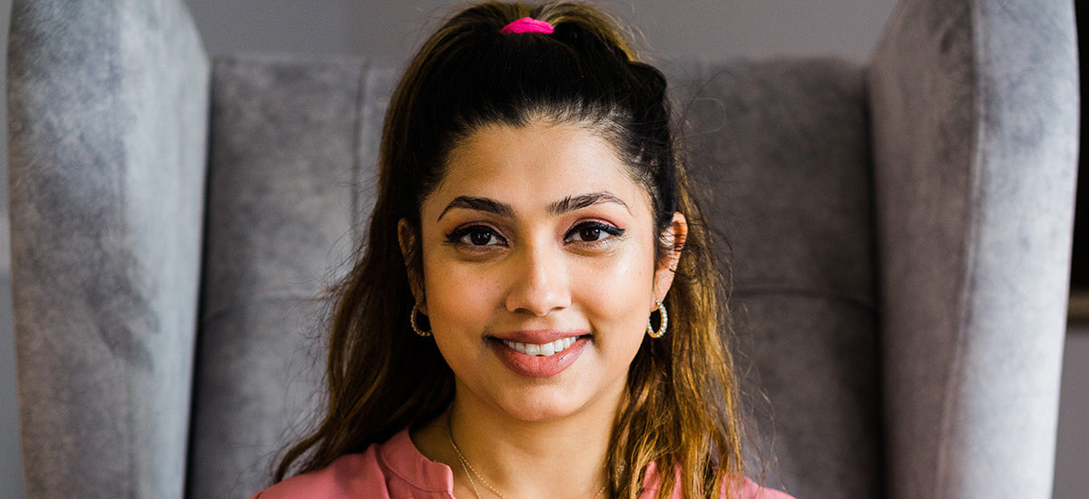 Close up of Kristyana Jimdar, a Counselling Children and Young People graduate. The photo is close up, showing Kristyana's face, her hair tied up behind her head and she is smiling towards the camera.