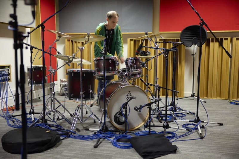 Musician playing the drums in a UON music studio