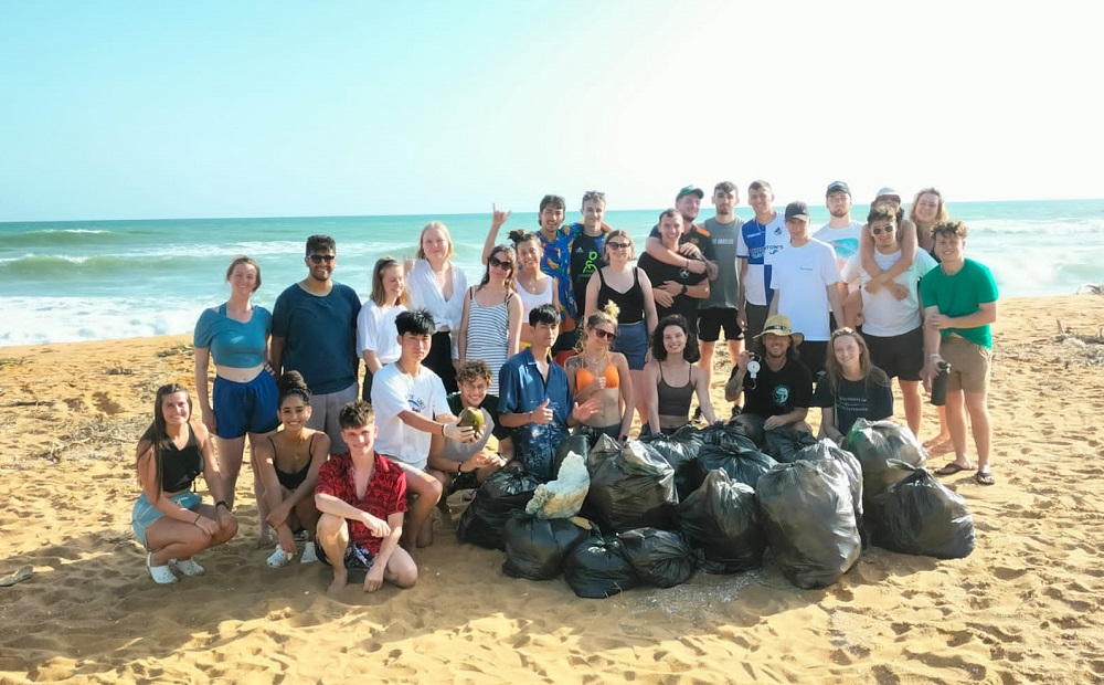 Graduate Matilda Nichols with a large group of volunteers on a beach in Hikkaduwa, Sri Lanka