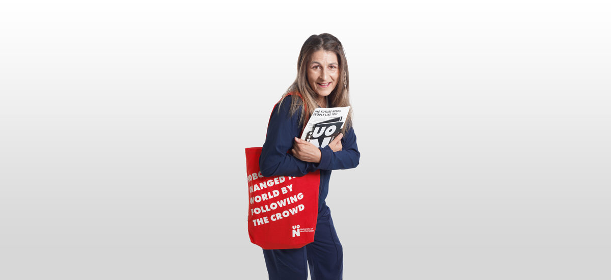Sarah Finucane, Podiatry student. Sarah is carrying a red UON 'nobody changed the world by following the crowd' bag and holding leaflets with UON black and white branding on them.