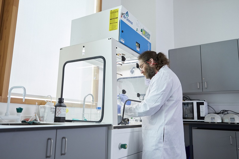 Student undertaking an experiment in a fume cupboard in a lab