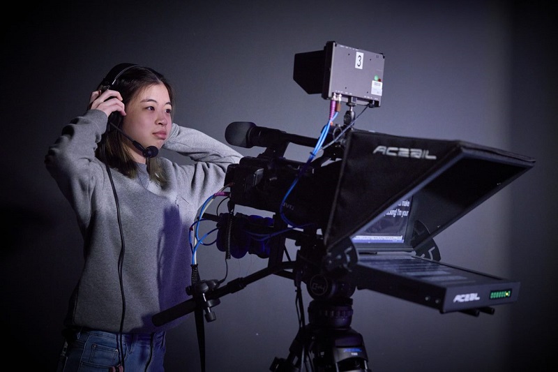 Film camera operator adjusting her headphones