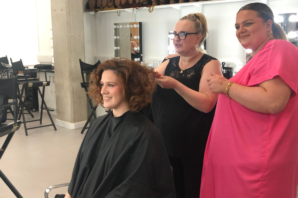 Makeover in chair with stylists touching hair