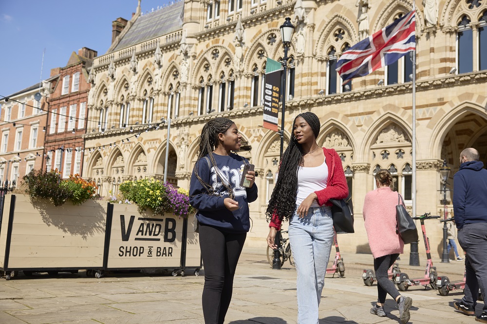 Two students standing in front of the Guildhall building in Northampton town centre.