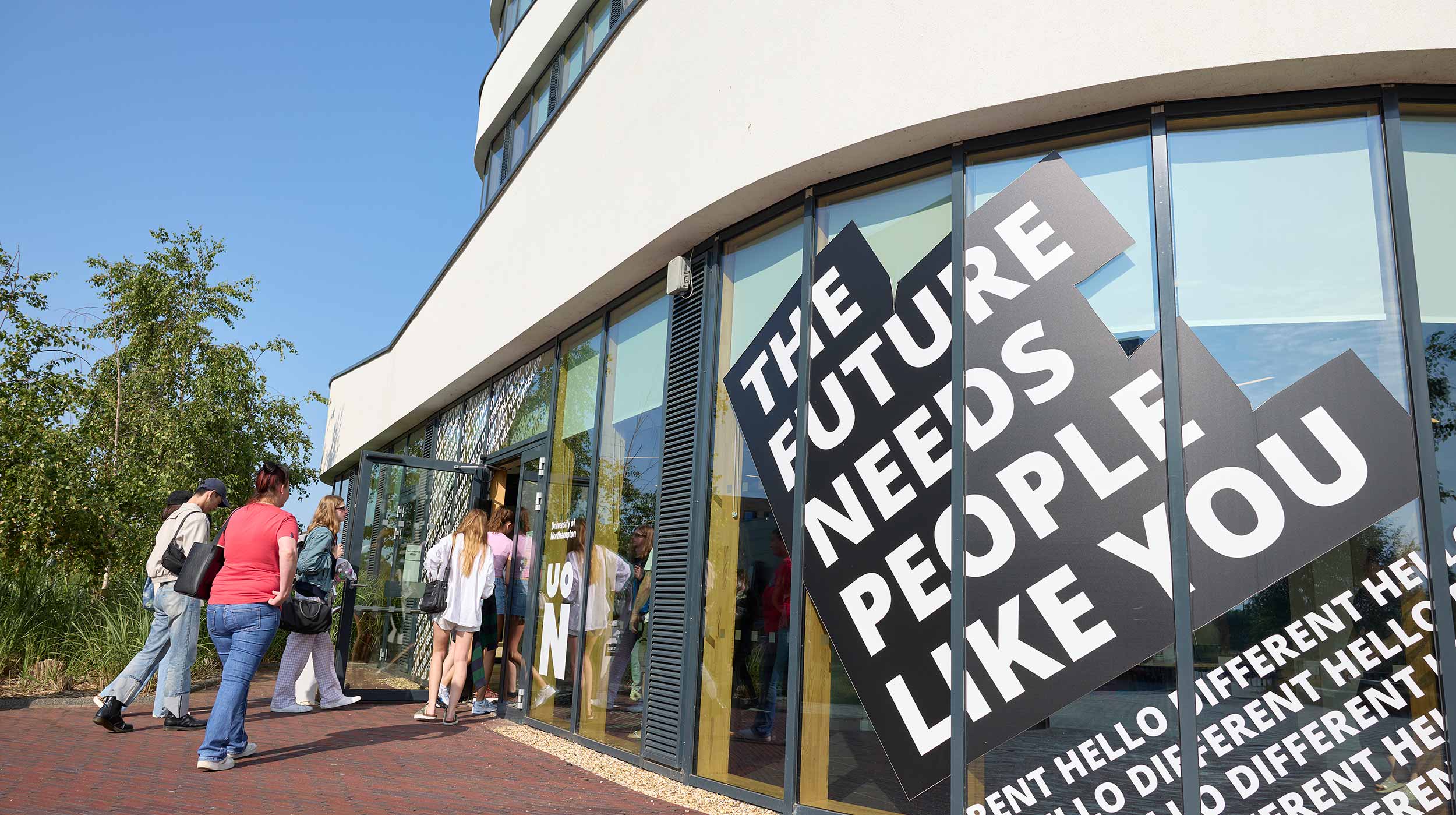 Visitors arrive at the Creative Hub on the morning of a University of Northampton open day. The display on the windows of the building says 'The future needs people like you'