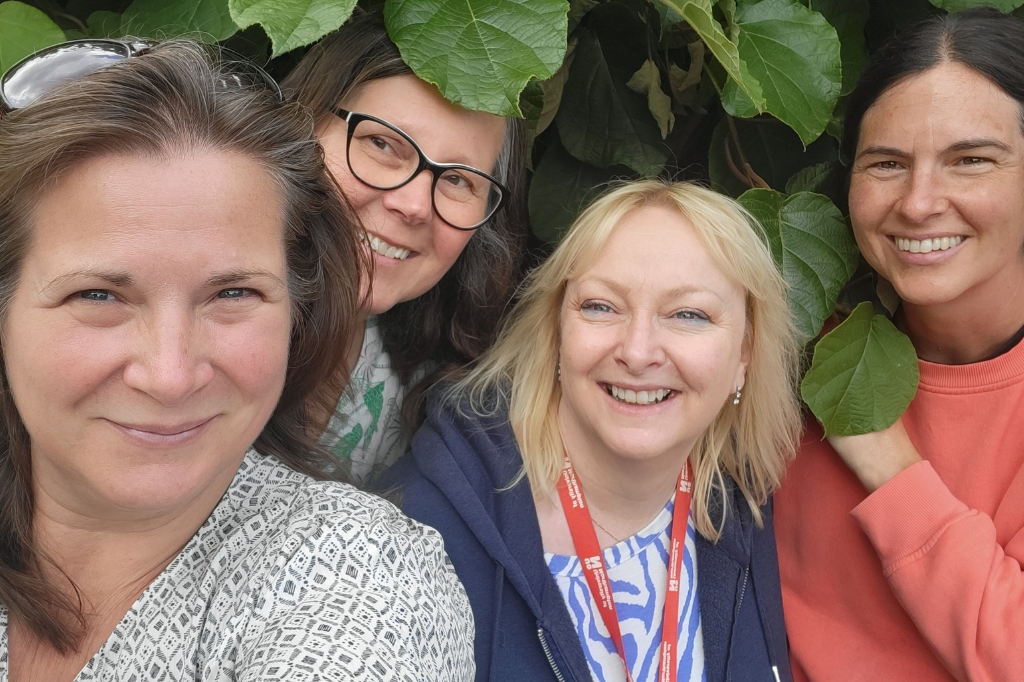 Group picture of four people smiling at camera.