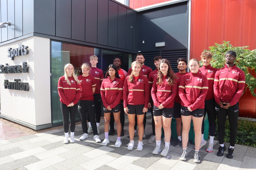 Elite Athlete Scholars stand in group in front of Sports Pavillion building.