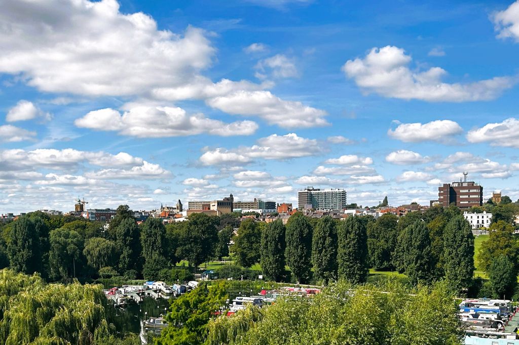 The Northampton skyline on a sunny day with puffy white clouds as viewed from the top of the University of Northampton