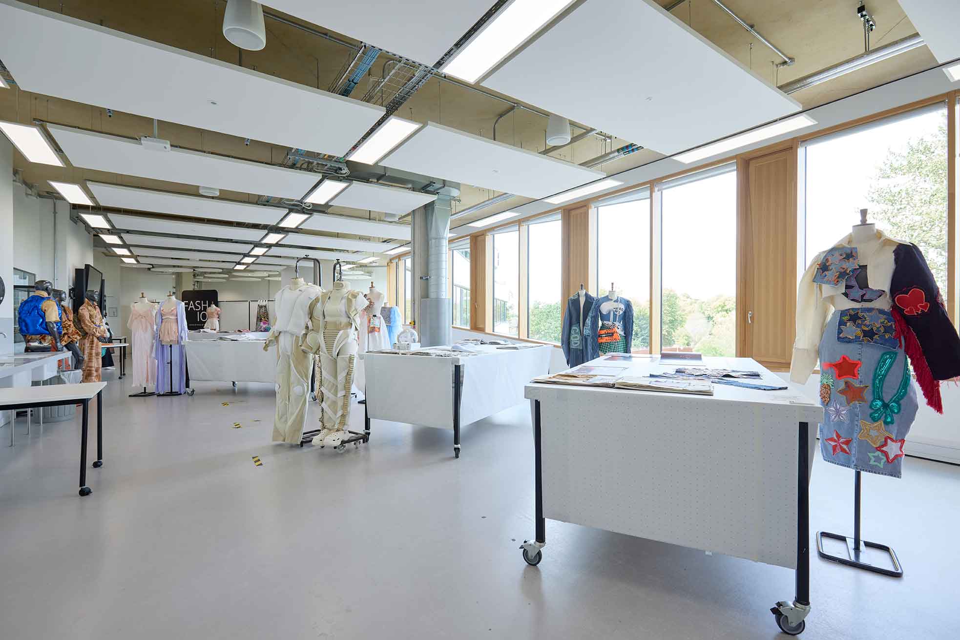 The photograph shows the Fashion studios with completed fashion designs displayed on mannequins