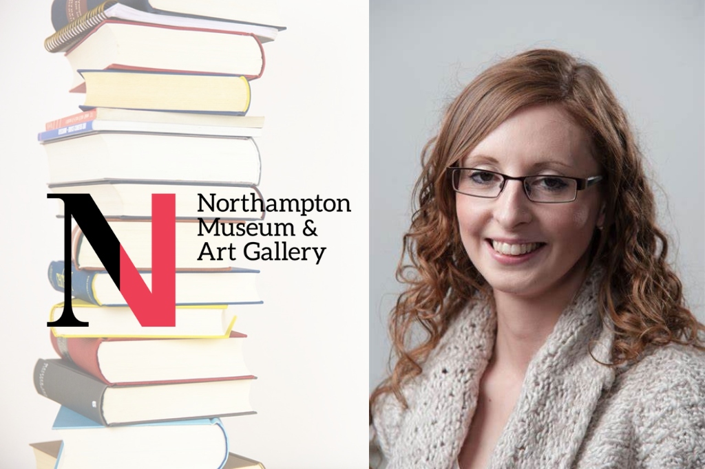 Claire Allen smiles at camera next to pile of books and Northampton Museum logo.