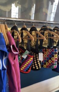 Various colourful halter-neck tops on hangers on a clothes rail