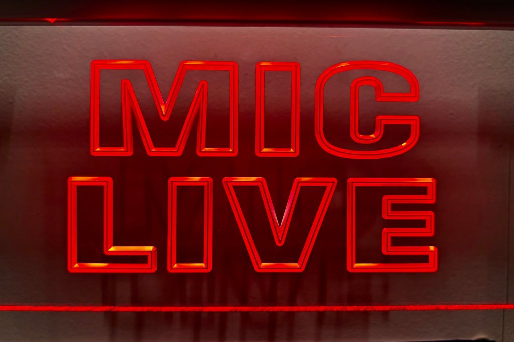 Red neon sign from a recording studio say Mic Live.