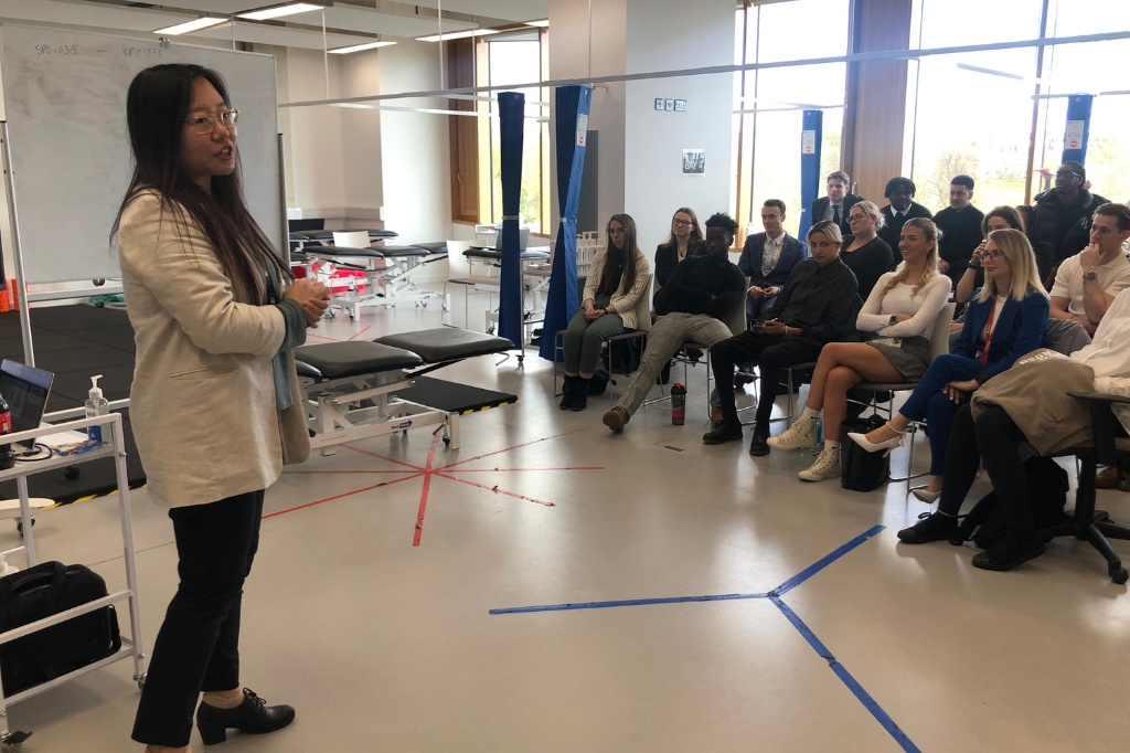 Dr Lucy Zhu talks in front of a group of attendees in sports lab at Waterside campus.