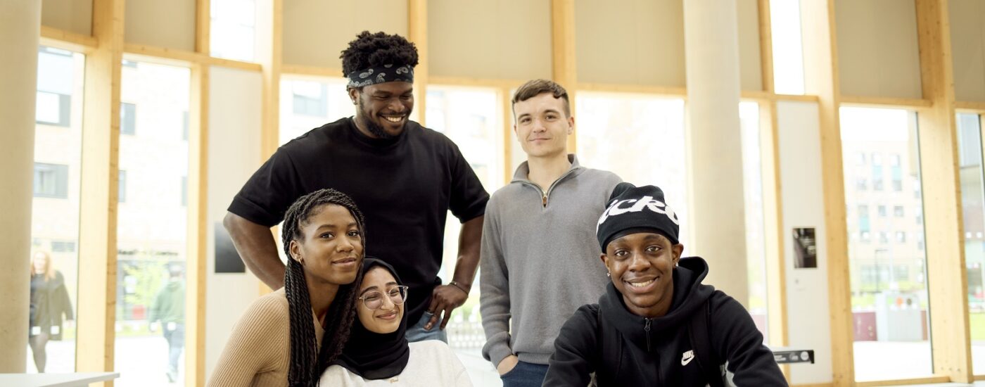 Five students are gathered around a table in the student restaurant.