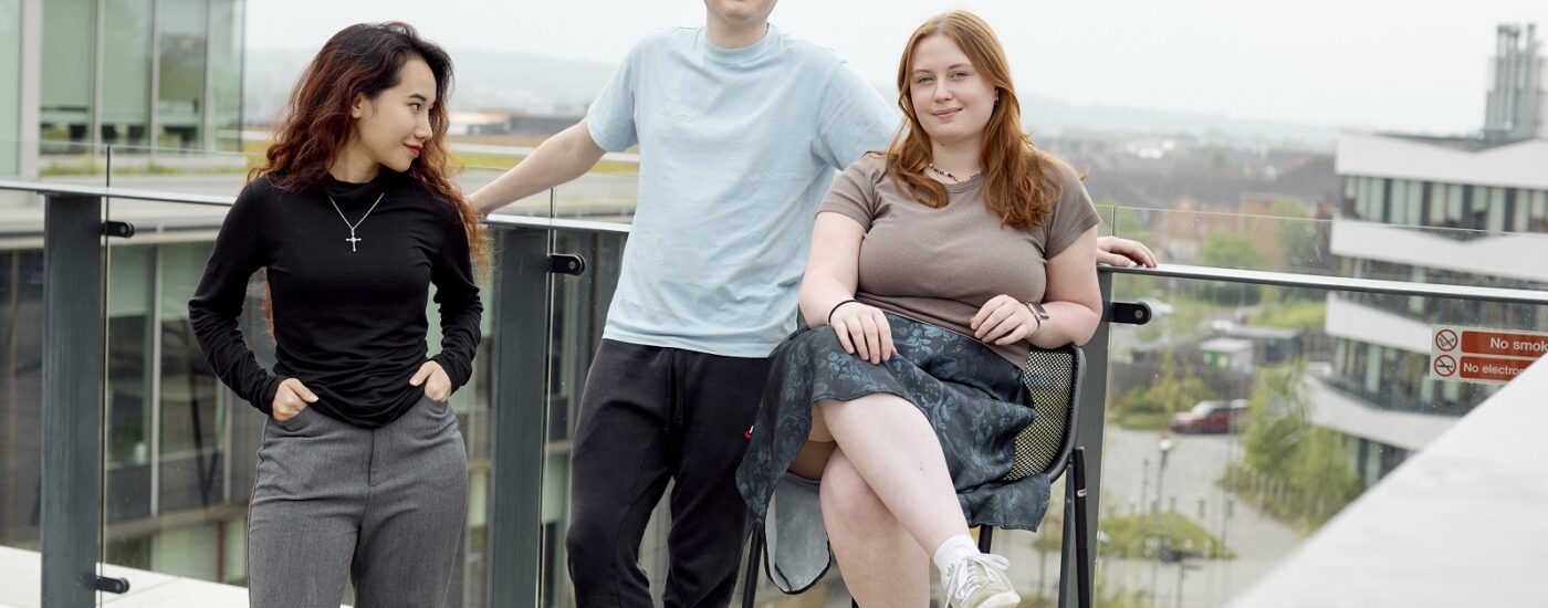 Three students on a rooftop terrace on Waterside campus.