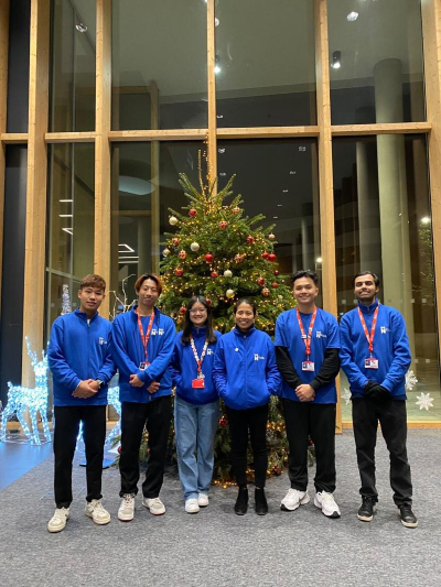 A team of 6 student ambassadors stood by an Xmas tree