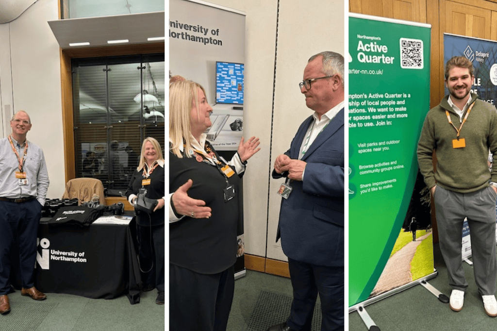 Three separate groups of people stand and talk near informational booths for the University of Northampton and Northampton's Active Quarter at an indoor event.