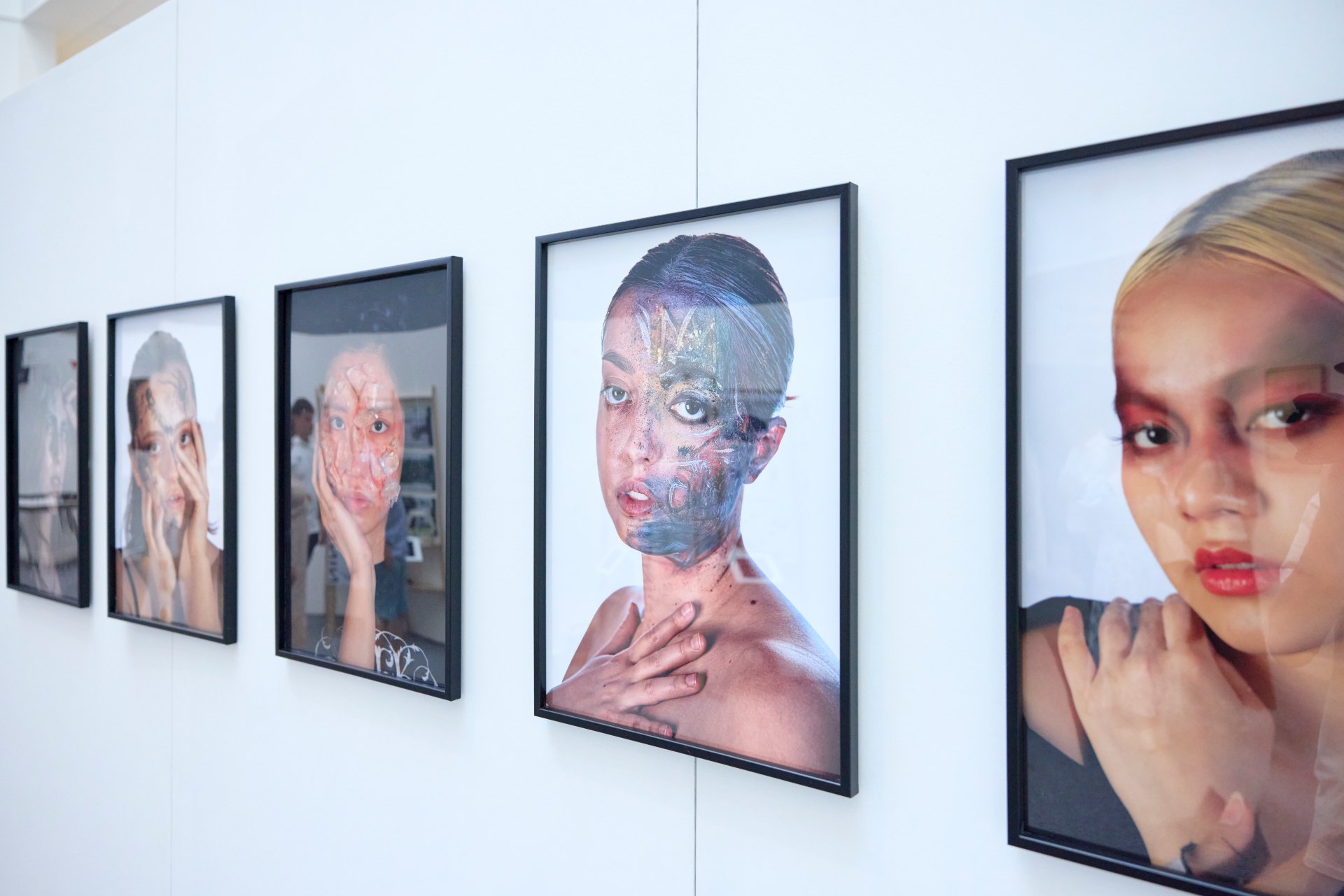 Framed photographic portraits displayed in a row on a white gallery wall as part of a university degree show exhibition