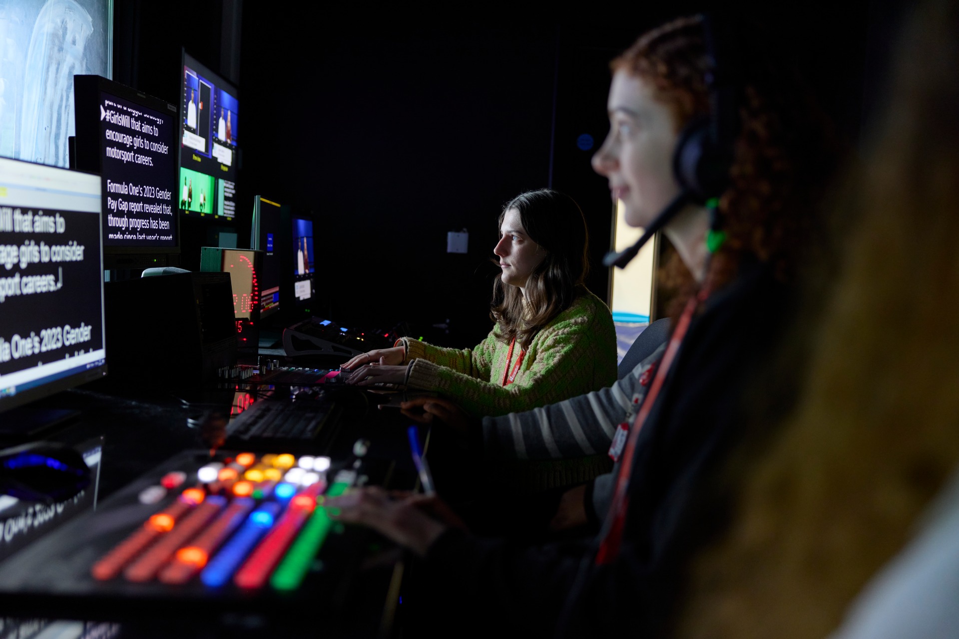Students in a TV control room managing live broadcast equipment and teleprompter feeds during a university journalism workshop.