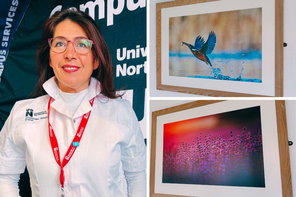 A woman in a white shirt and red lanyard stands beside two framed nature photographs, one of a bird over water and one of pink-tinged droplets.