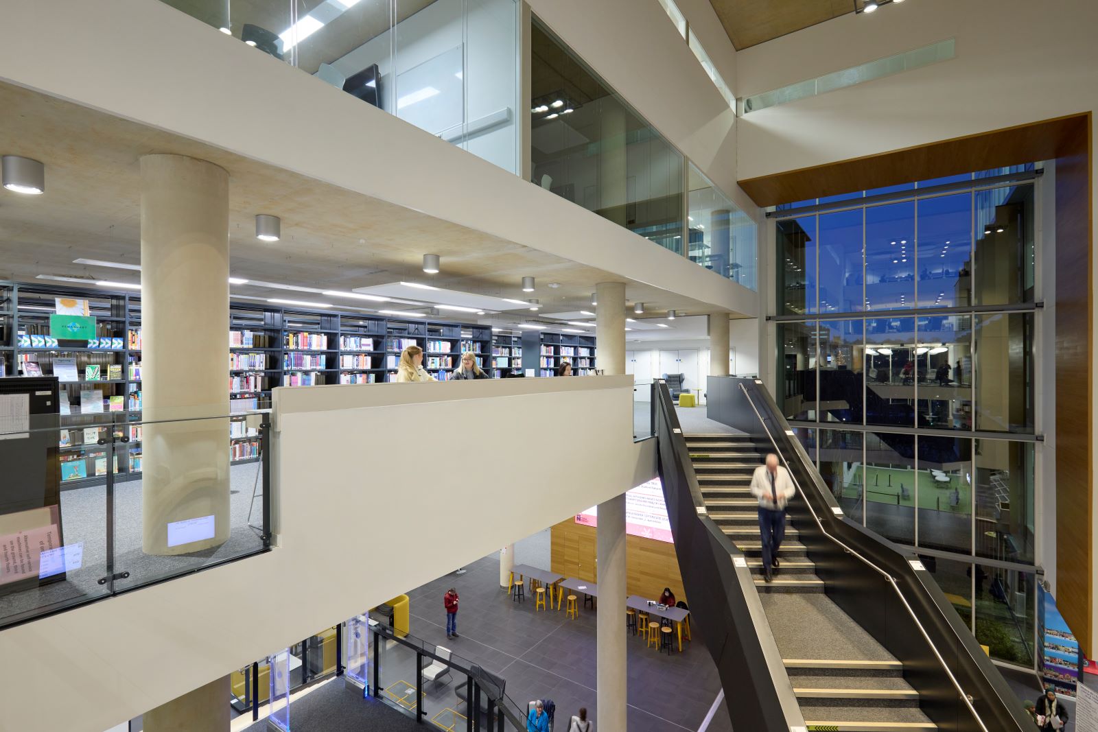 View of the internal staircase in the Learning Hub to the library on the second floor. It is a large and airy, well-lit space.