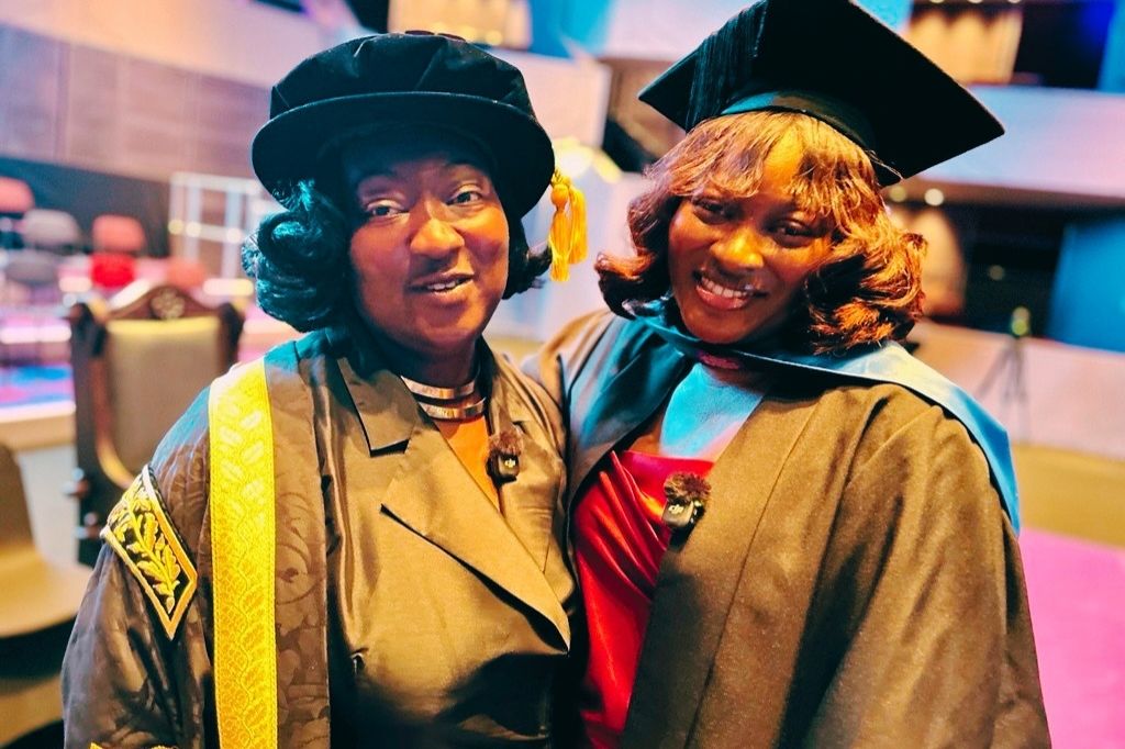 Lady Phyll and Edna Quarshie dressed in graduation gowns and hat on the stage at Derngate Theatre.