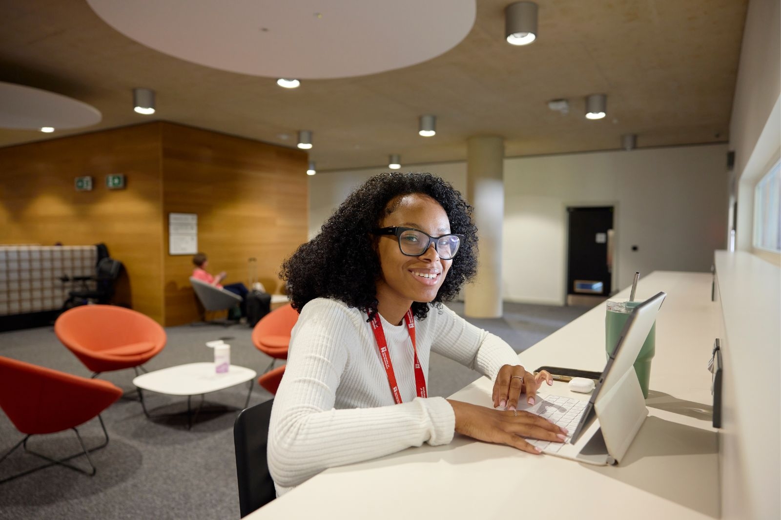 Student smiling at a laptop.