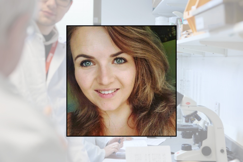 Danielle smiles at the camera, with a scene of a laboratory and petri dishes behind her.