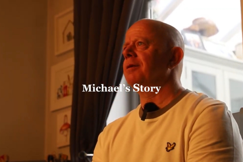 'Michael's Story' is written in text in the centre of the screen with an image of a man looking to the side behind it.