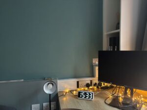 A desk in Joe Kelly's study bedroom, featuring a computer screen, fairy lights and a clock radio.