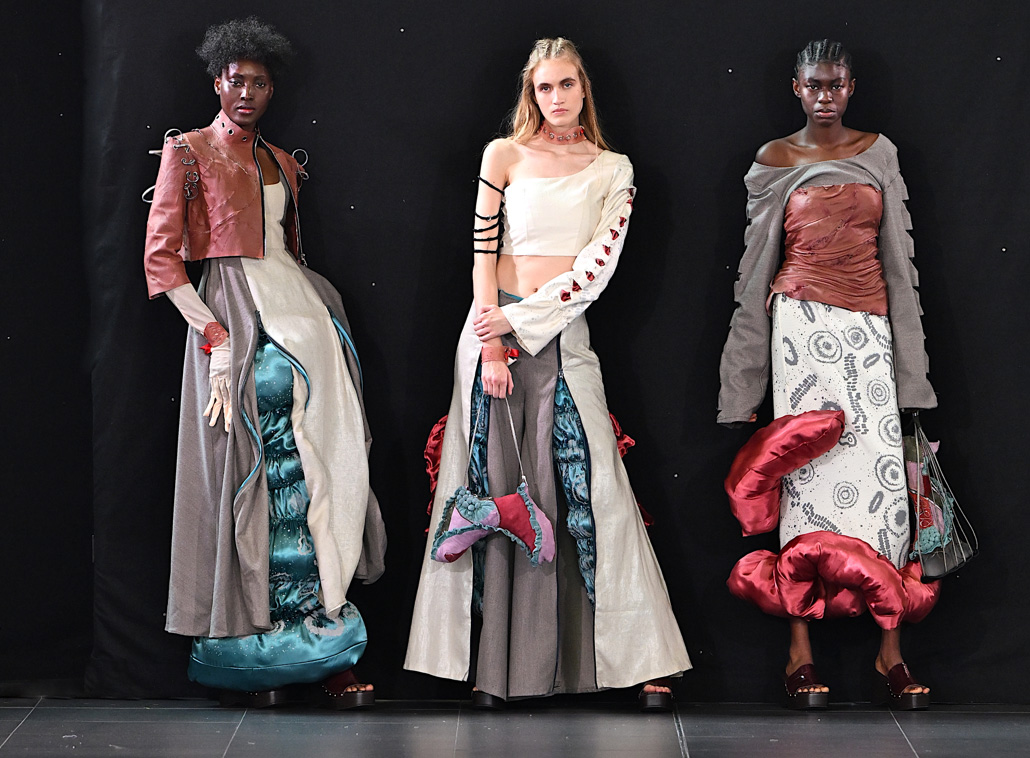 Catwalk photograph of fashion models wearing student designed fashion collections, complete with accessories, at the Northampton Fashion Show on 18 June. The garments were designed and produced by Level 5 students as part of their team project.